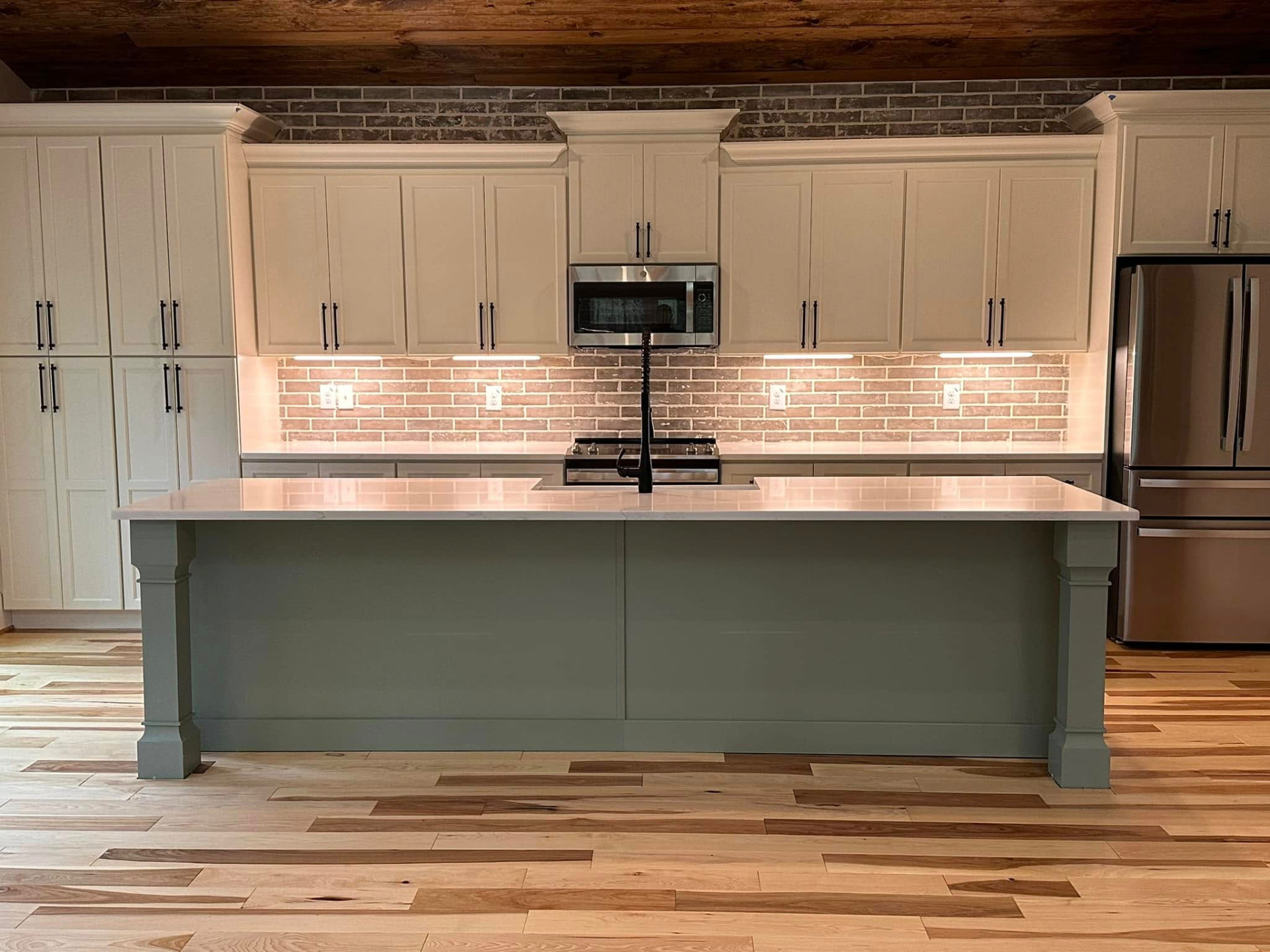 Kitchen with brick backsplash and sage island